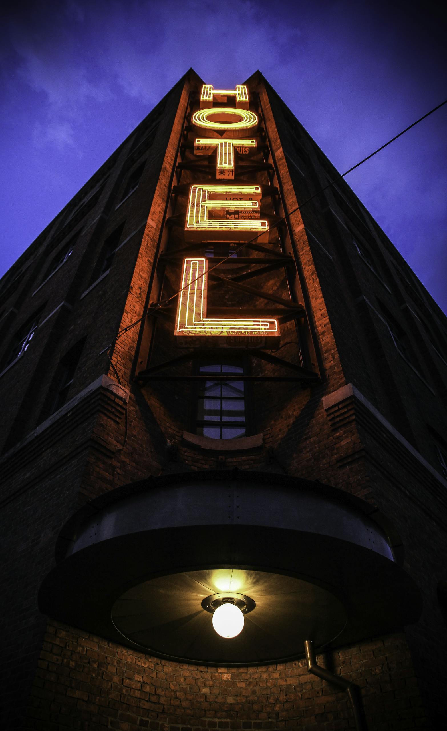 Hotel Signage in yellow and red neon vertical lights